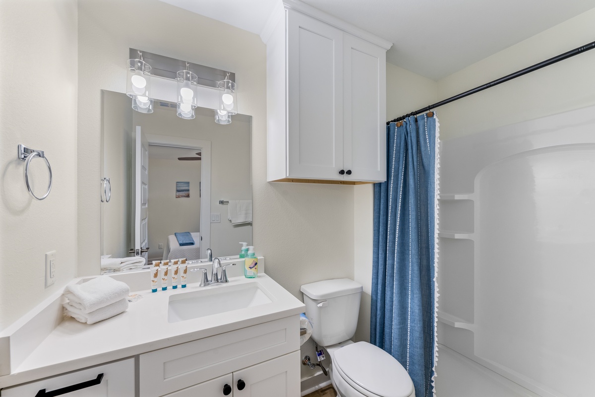 Your pristine bathroom features modern vanity lighting, fresh white linens, and a spacious shower for refreshing mornings.
