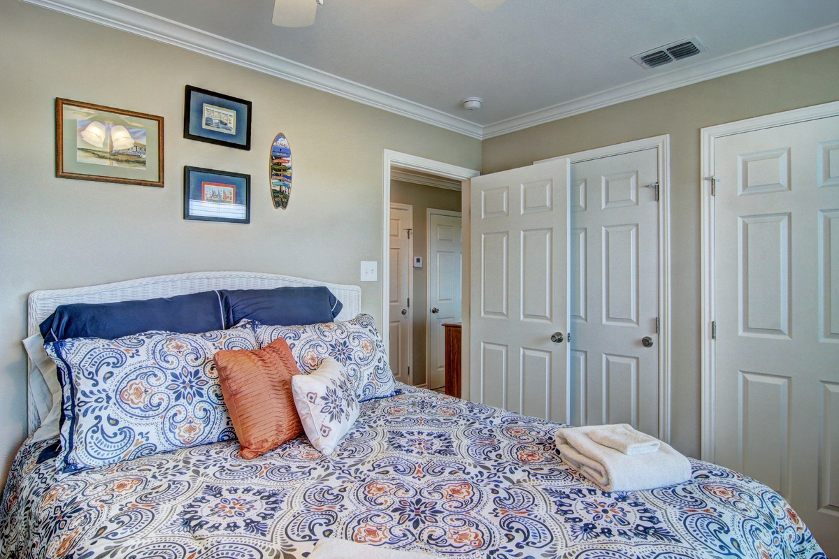 Drift off peacefully in this charming bedroom featuring nautical artwork and elegant blue paisley bedding that invites sweet dreams.