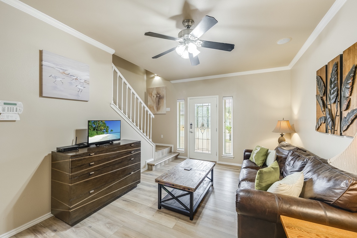 Relax in your spacious living room with comfortable leather seating, flat-screen TV, and ceiling fan to keep you cool.