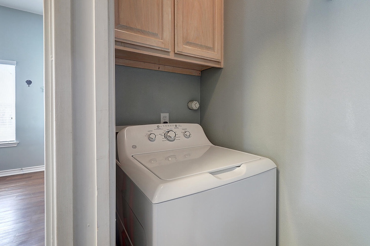 Your in-unit laundry nook keeps your clothes fresh with a full-size washer tucked neatly beneath custom cabinetry.
