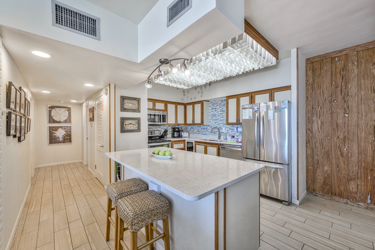 You'll love cooking in this bright, modern kitchen with its spacious island, sparkling countertops, and coastal-inspired design touches.