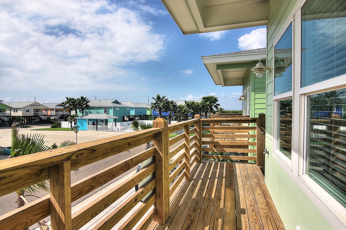 Step onto your private wooden deck and breathe in the coastal breeze while enjoying views of colorful beach houses.