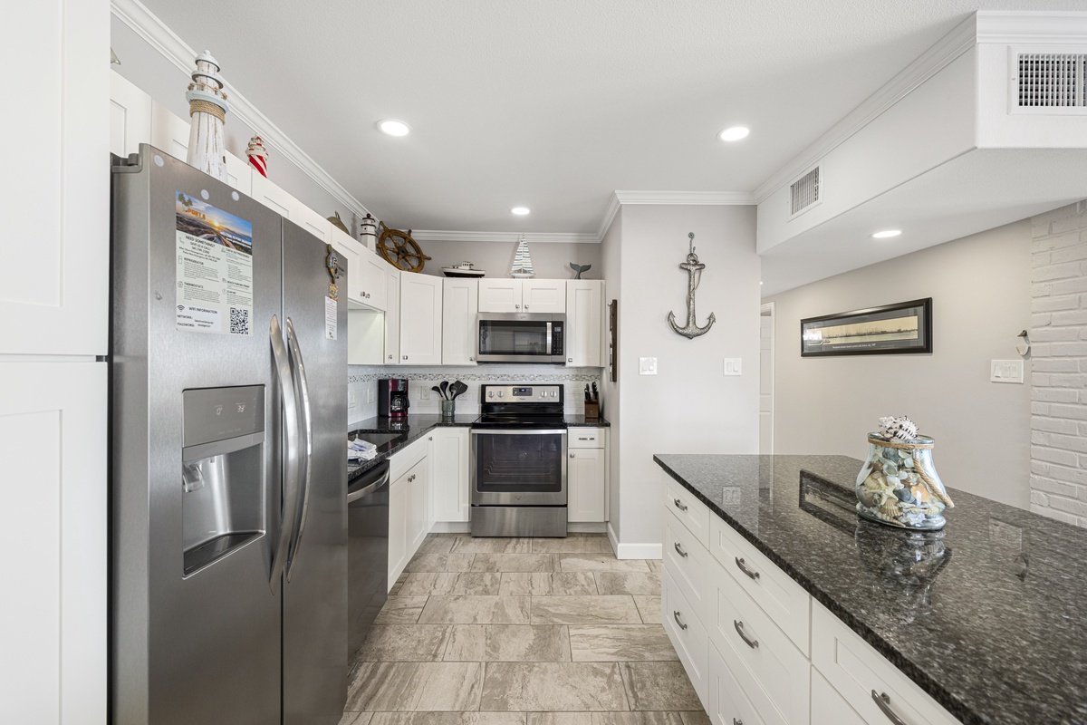 Your fully equipped kitchen features granite countertops, stainless steel appliances, and nautical touches that inspire culinary adventures during your coastal getaway.