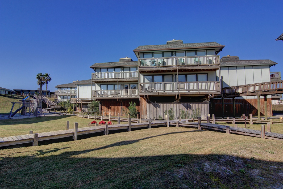 Multi-level beachfront property with private docks and waterfront access on clear sunny day.