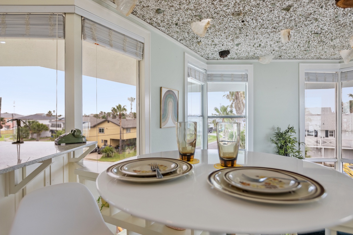Enjoy meals with stunning neighborhood views from your bright dining space, featuring elegant place settings and natural light.