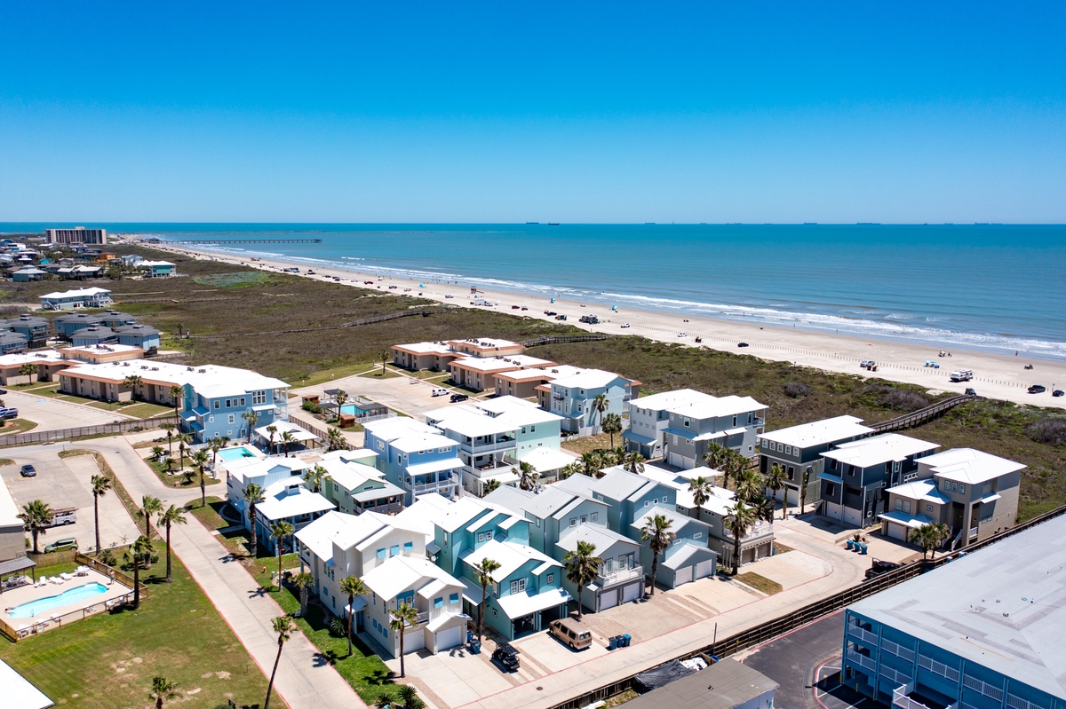 Beachfront community with colorful coastal homes just steps from pristine white sand and rolling waves.