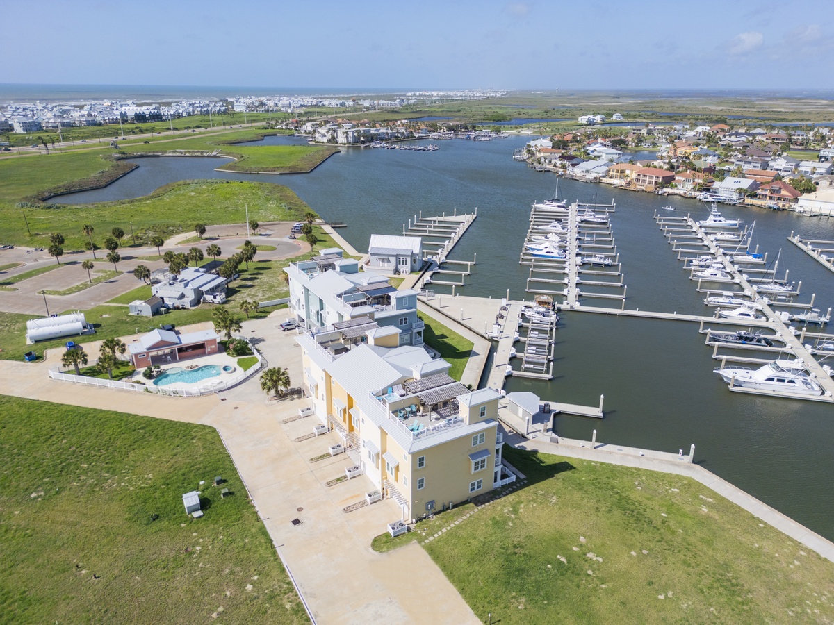 Waterfront resort with marina, boats, and coastal community in scenic bay setting.