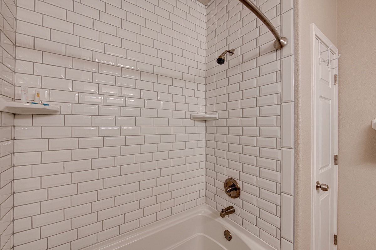 Refresh in your pristine bathroom with elegant subway tile surround, rainfall shower, and thoughtful amenities for a spa-like experience.