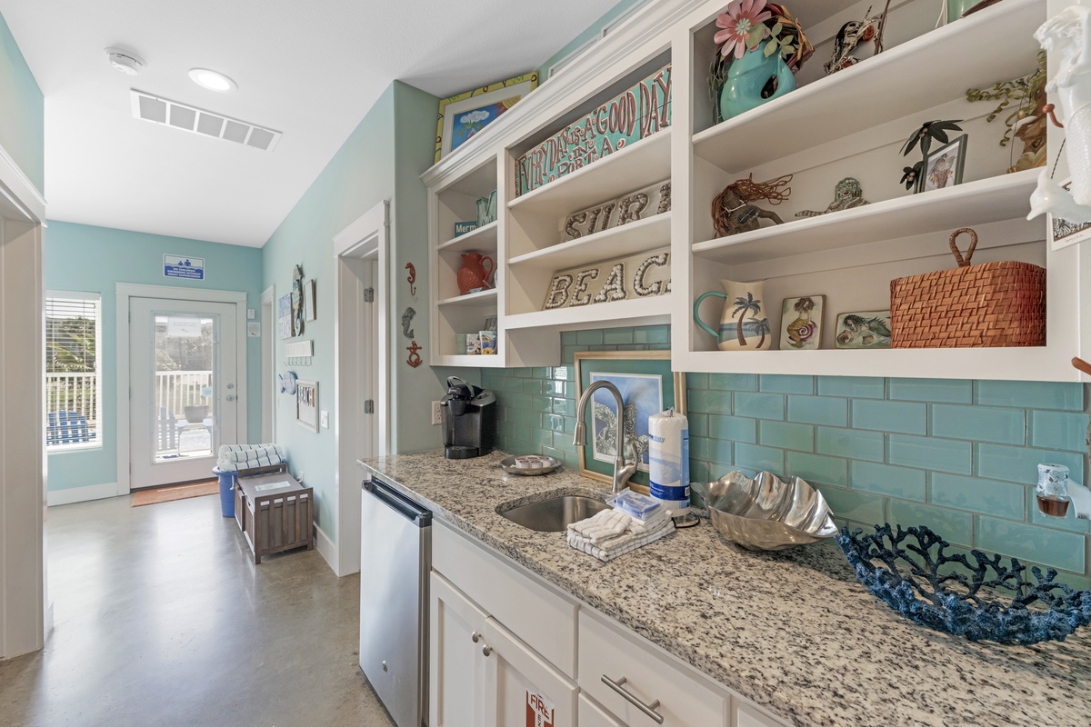 Step into your coastal-themed kitchen where sea glass tiles and open shelving create a beachy vibe for preparing meals.