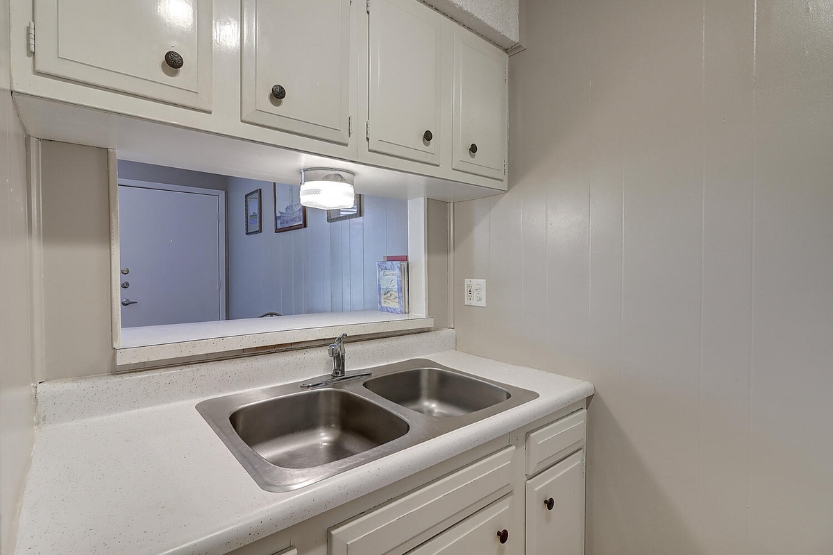 Your kitchen features a double sink, ample cabinet storage, and convenient pass-through window connecting to the living area.