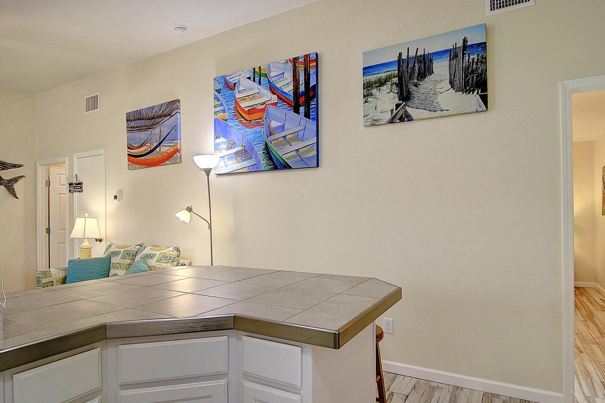 Your open kitchen island creates the perfect gathering spot, with coastal artwork setting a relaxing beach house vibe.