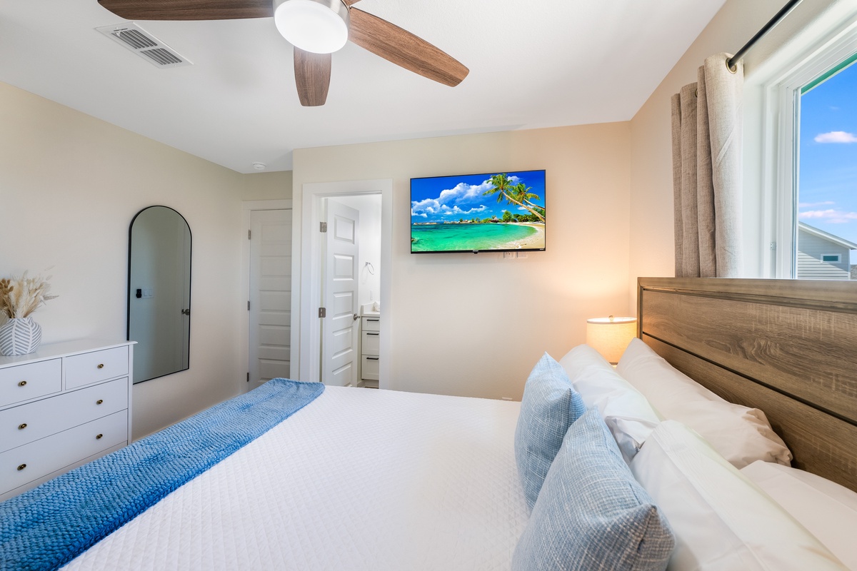 Drift off in your serene bedroom with coastal charm, wood accents, and gentle ceiling fan breeze.