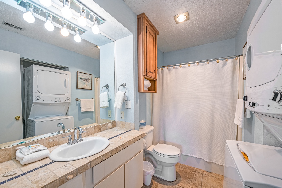 Your full bathroom features a tiled vanity, spacious shower, and convenient in-unit laundry facilities for your comfort.