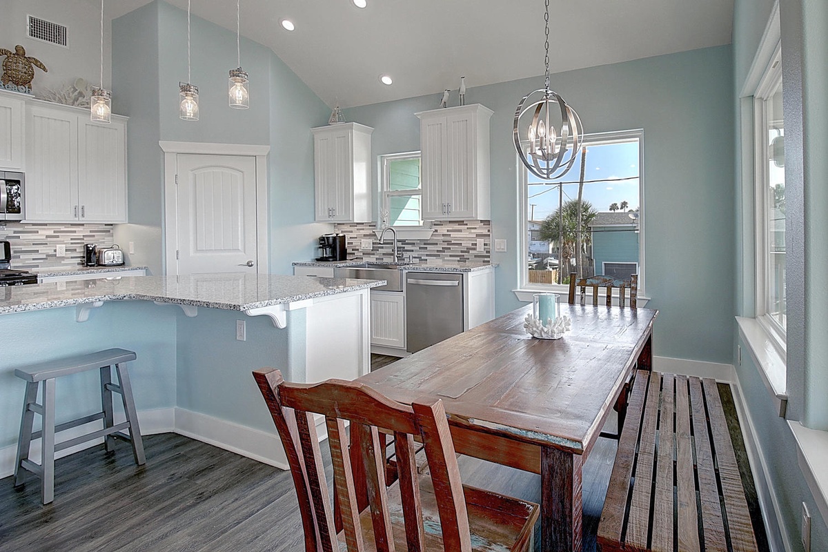 Your open kitchen flows seamlessly into the dining space, where coastal-inspired colors and elegant pendant lighting create the perfect atmosphere for memorable meals together.