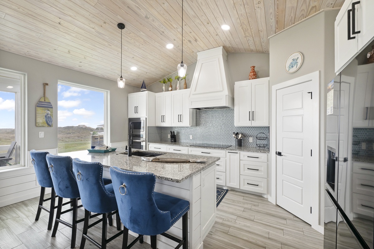 Your gourmet kitchen awaits with granite countertops, stainless appliances, and stylish blue bar seating for memorable meal prep.