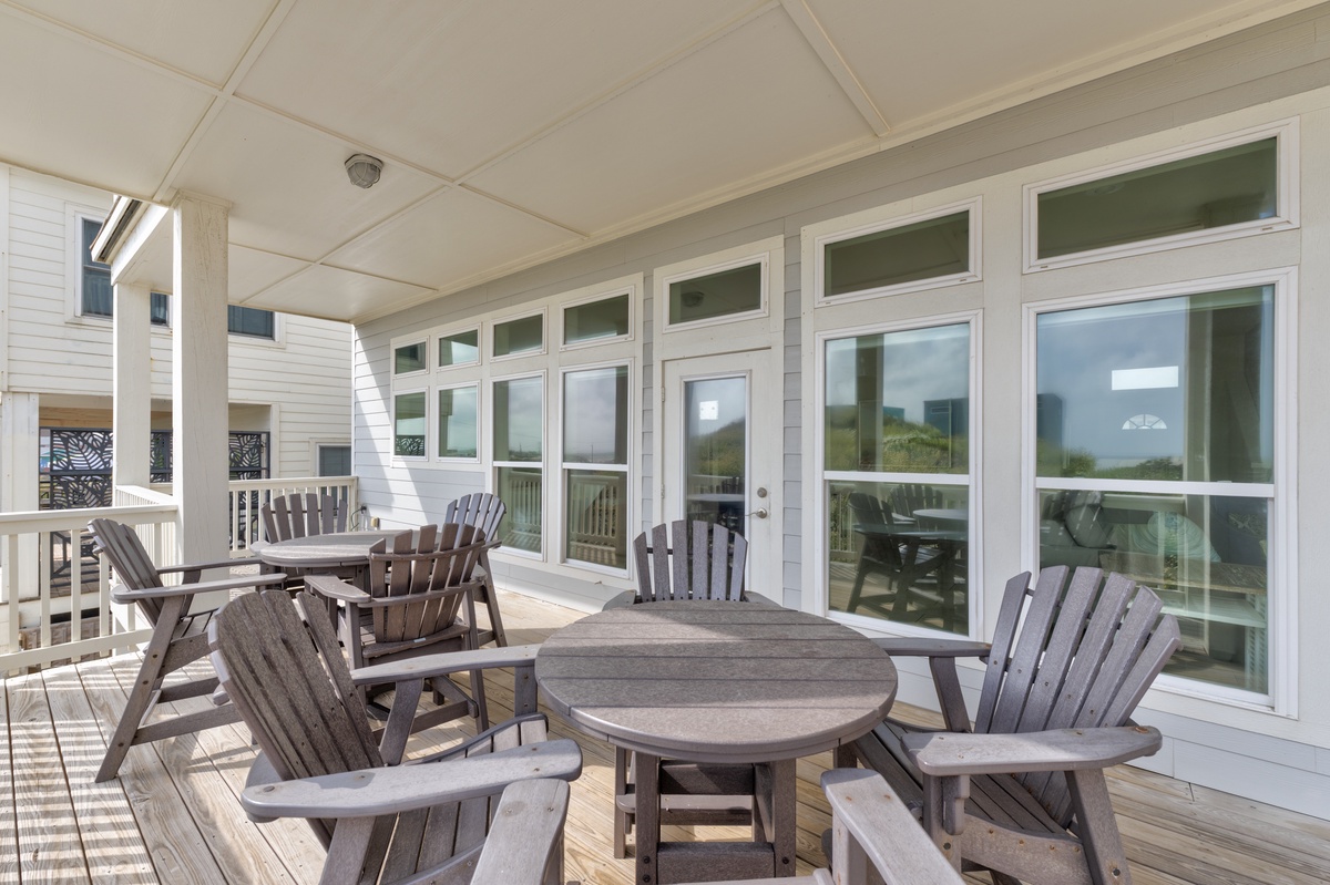Your covered deck offers peaceful morning coffee moments with Adirondack chairs, dining table, and large windows inviting the outdoors in.