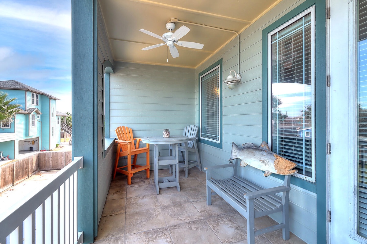 Your covered porch offers peaceful morning coffee moments with colorful seating and gentle ceiling fan breezes.
