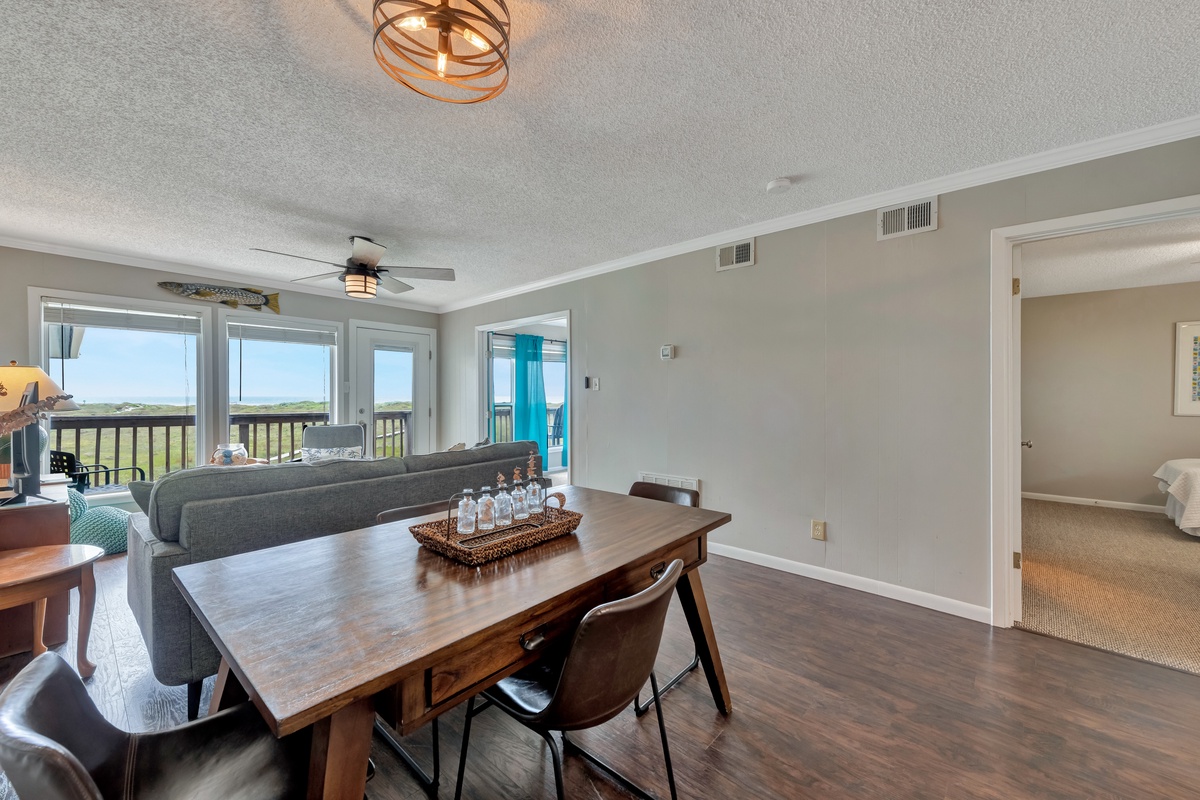 Gather around this beautiful dining table while enjoying stunning natural views through floor-to-ceiling windows that flood your space with light.