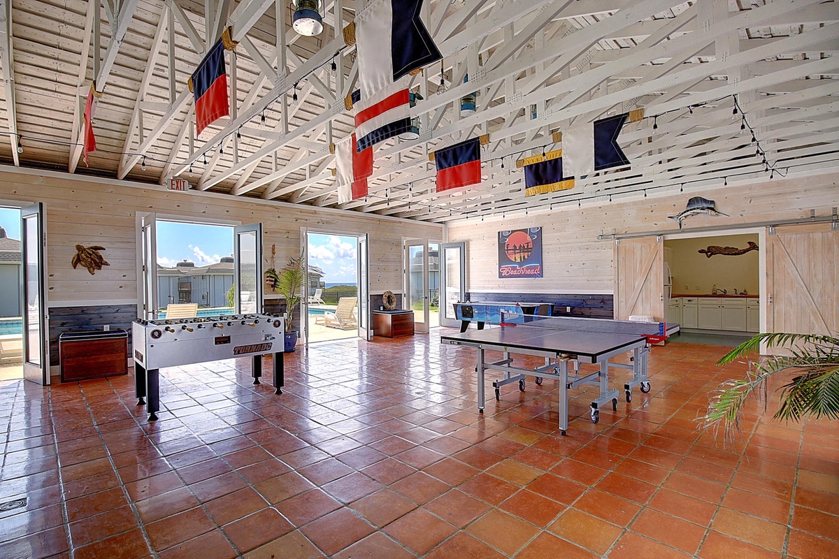 Challenge friends to ping pong or foosball in this nautical-themed game room with soaring ceilings and ocean views.
