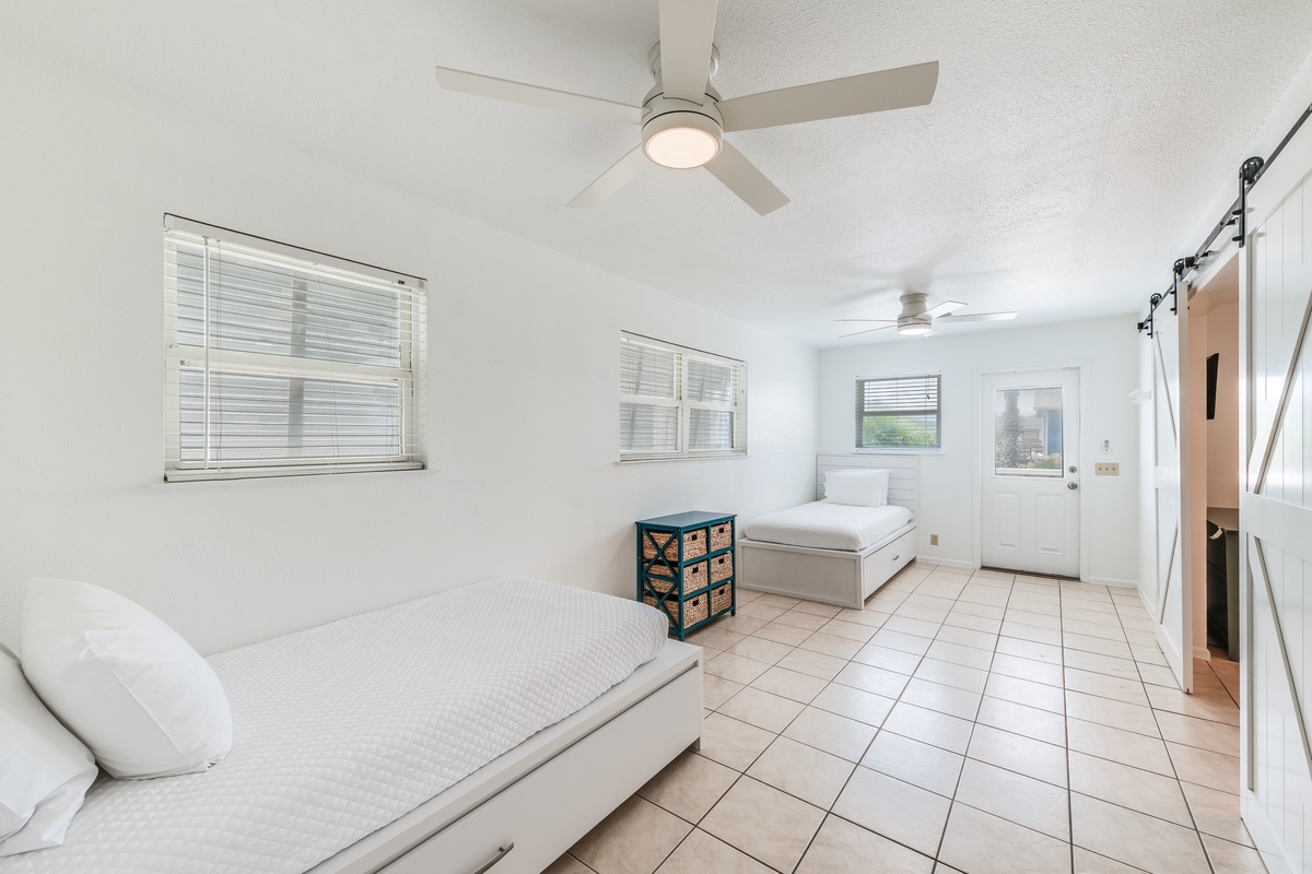 Unwind in your bright bedroom with twin beds, ceiling fans for comfort, and charming tile floors that keep you cool.