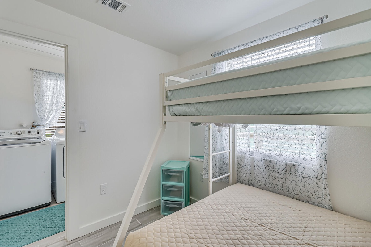 Your cozy bedroom features a space-saving bunk bed setup with comfortable mattresses, plus convenient laundry access right next door.