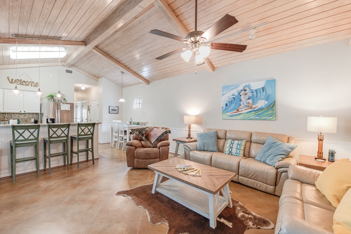 Relax in your spacious living room with vaulted ceilings, leather sectional, and coastal artwork. The open layout flows into your kitchen.