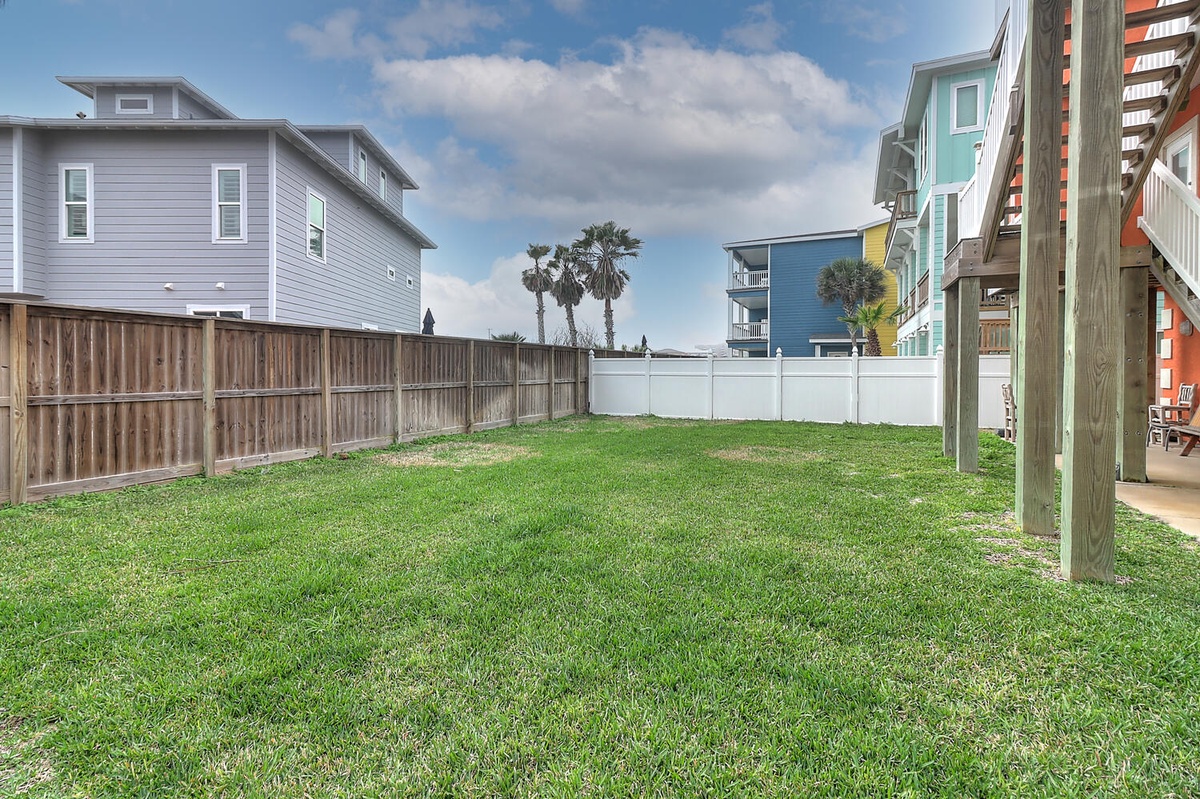 Spacious private yard with lush green grass where you can relax, play games, or enjoy peaceful moments under the open sky.
