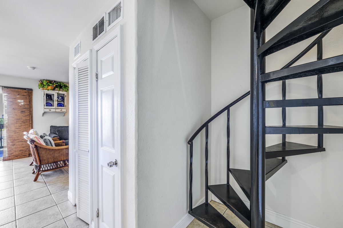 Your private spiral staircase leads to additional spaces, while cozy seating awaits nearby for relaxing moments.