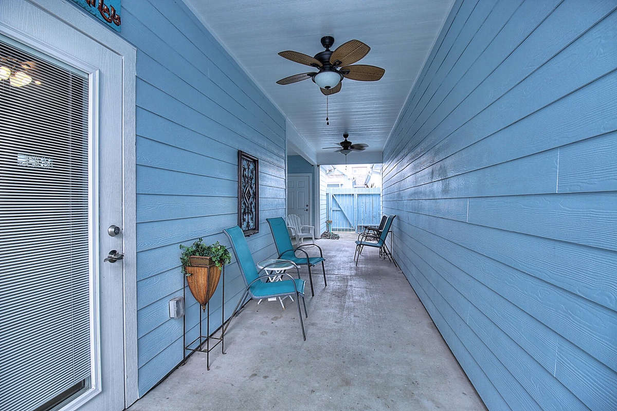 Unwind on your private covered porch with turquoise chairs and ceiling fans creating the perfect breeze for morning coffee or evening relaxation.