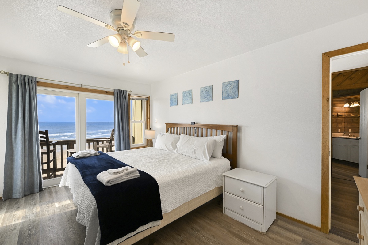 Cozy primary bedroom features a comfy bed with crisp linens and a ceiling fan to keep you cool.