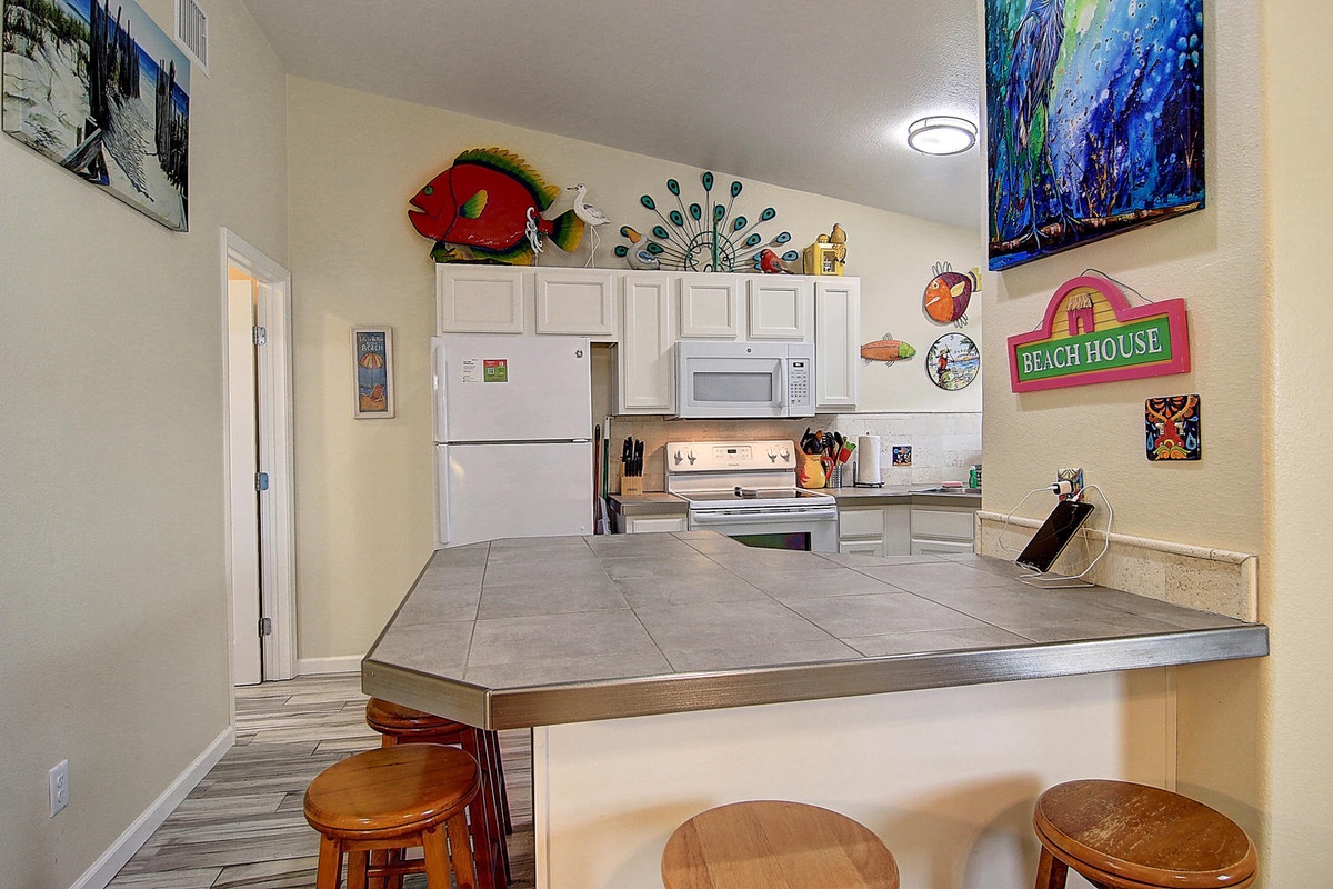 Your beach-themed kitchen features full appliances and a breakfast bar where you can start each morning with coffee and ocean views.