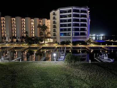 Modern waterfront property illuminated against the night sky, creating stunning reflections in calm waters.