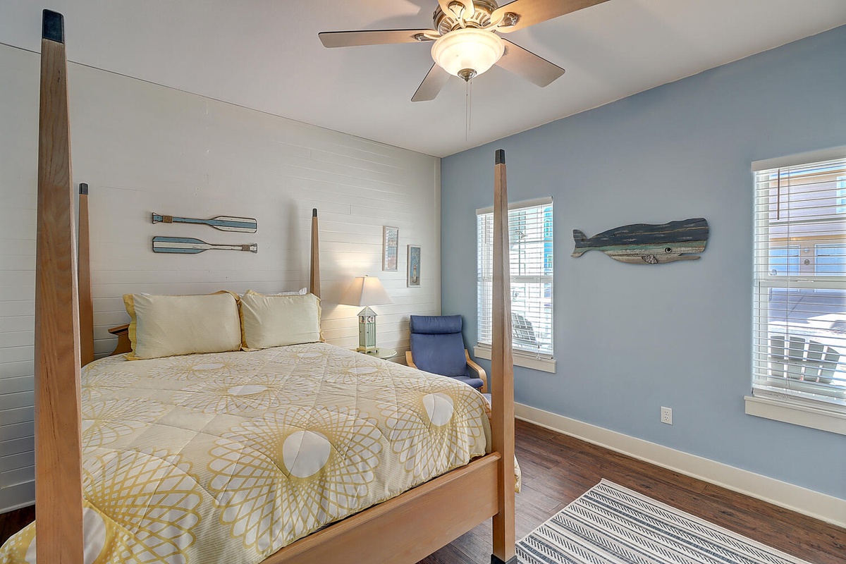 Rest peacefully in your coastal-themed bedroom featuring a four-poster bed, calming blue walls, and nautical artwork that creates a serene seaside retreat.