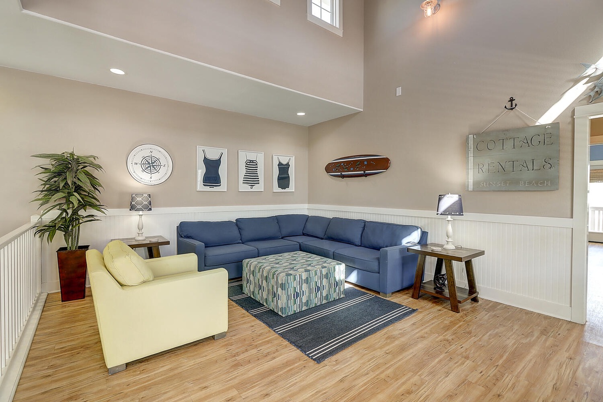 Unwind in this bright coastal living room with vaulted ceilings, cozy sectional seating, and charming nautical touches that make you feel right at home.