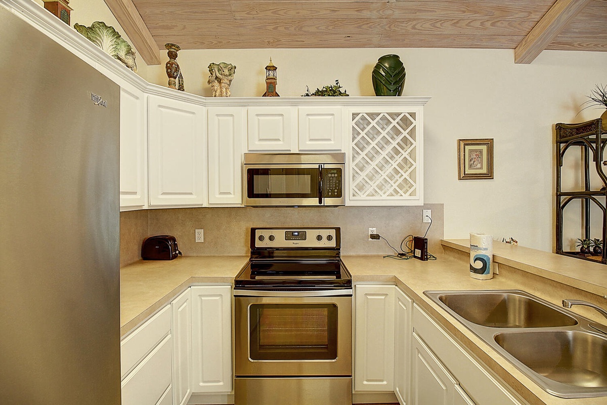 Your fully equipped kitchen awaits with crisp white cabinets, stainless appliances, and thoughtful touches that make cooking feel effortless.