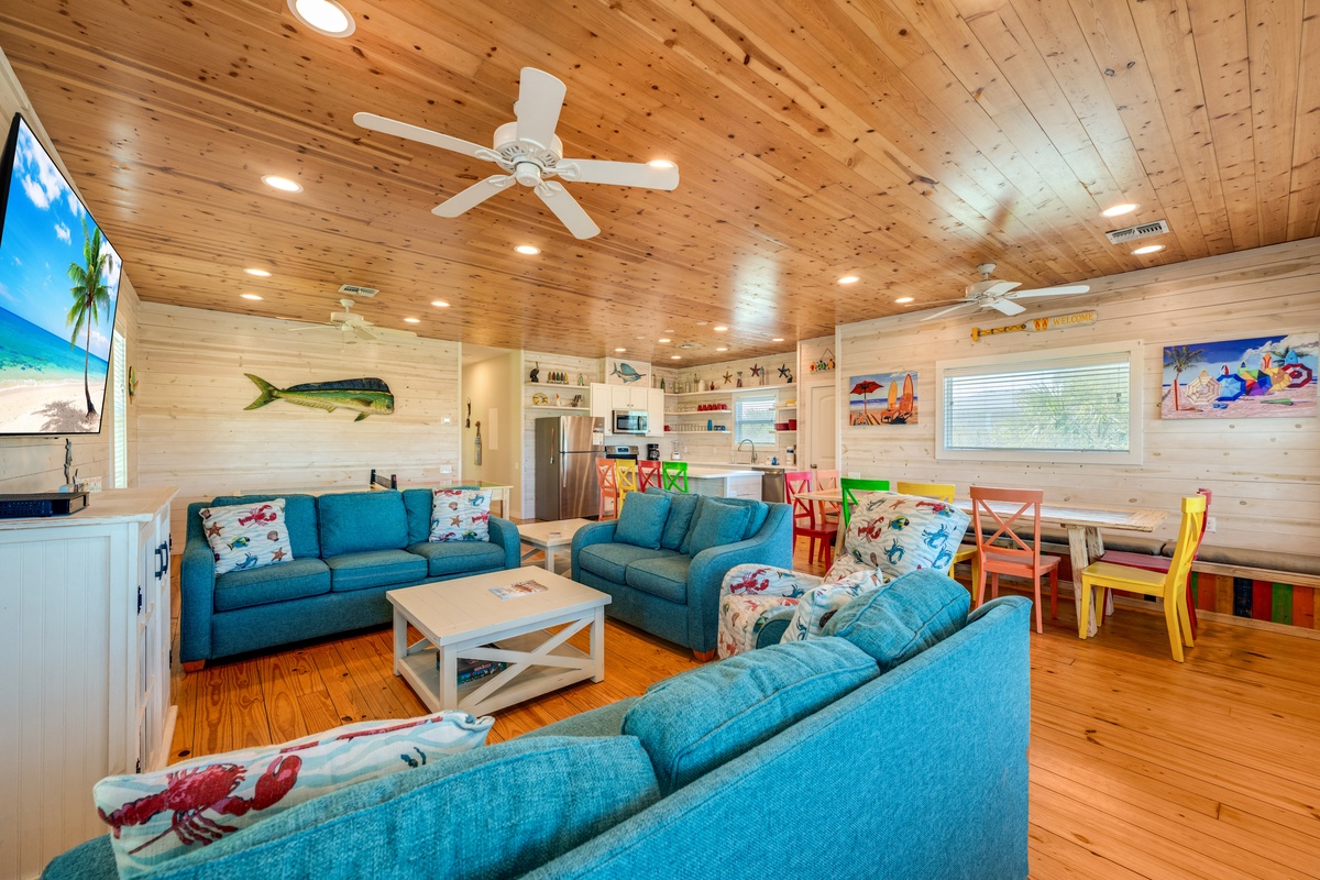 Sink into coastal comfort in this bright living space, where ocean-themed touches and colorful chairs create your perfect beach house retreat.