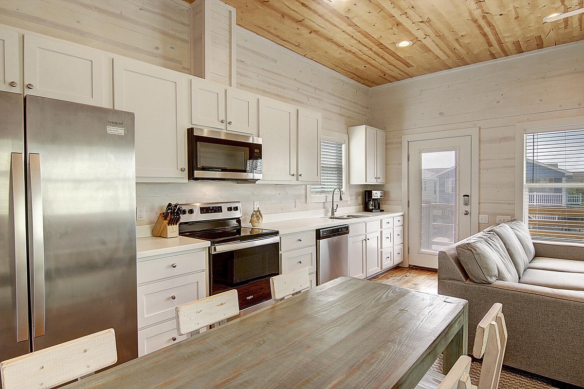Your cozy open-concept space blends rustic wood beams with modern amenities, where you can cook and relax seamlessly.