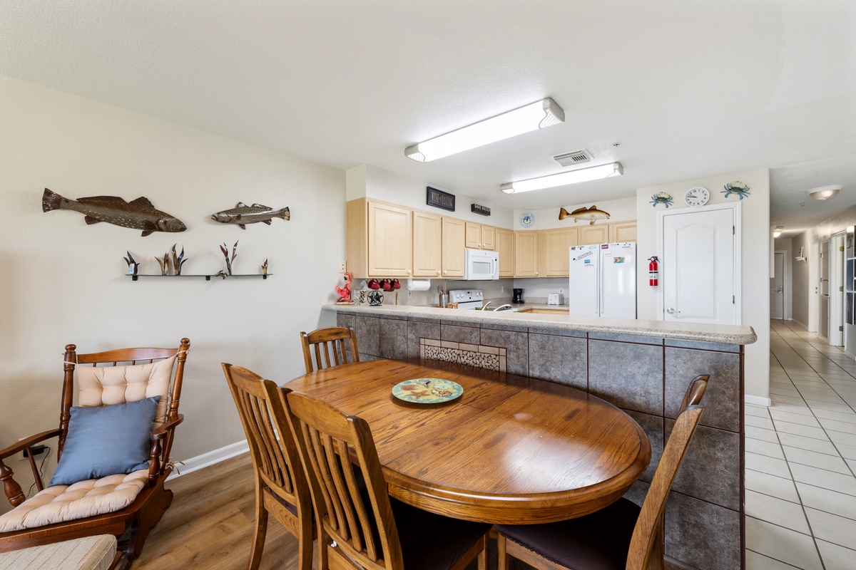 Gather around your dining table and enjoy meals together in this open kitchen space, complete with modern appliances and coastal charm.
