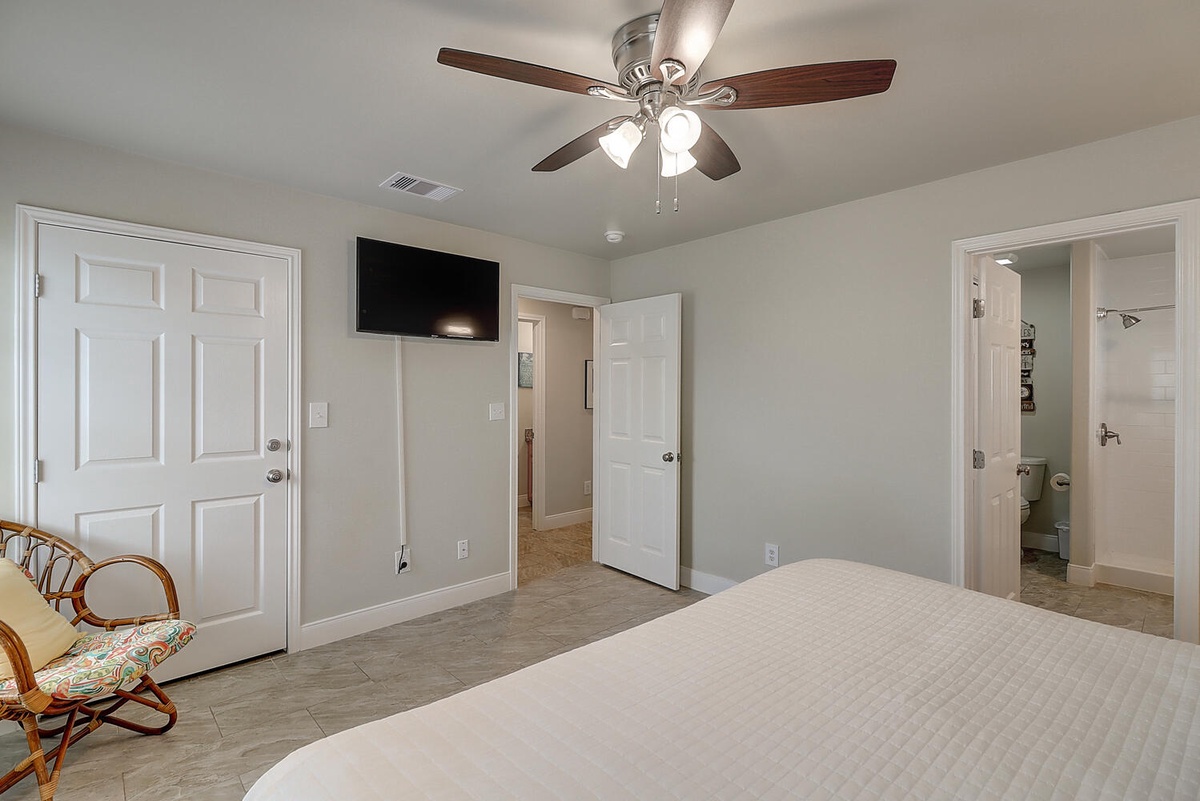 Your master bedroom offers peaceful comfort with ceiling fan, TV, and ensuite bath access for ultimate convenience.