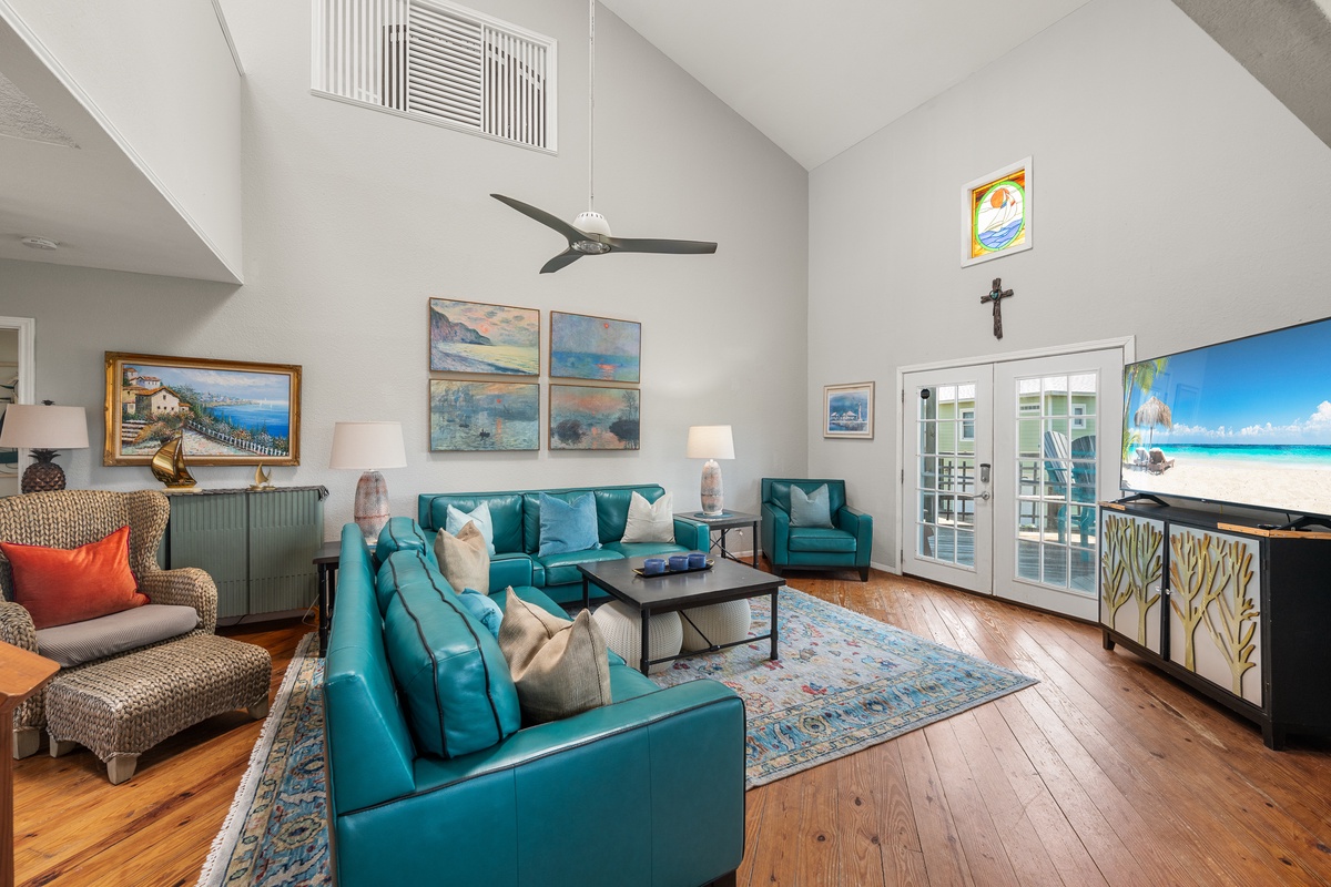Settle into plush turquoise seating in this airy living room, where vaulted ceilings and warm wood floors create a welcoming retreat for your group to gather and unwind together.