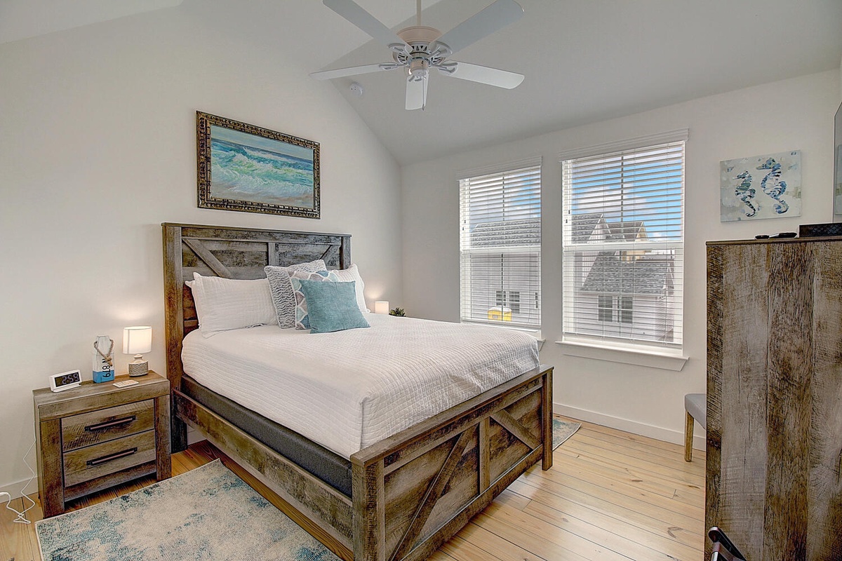 Your peaceful bedroom retreat features rustic wood furnishings, ocean-inspired art, and crisp linens for restful nights.