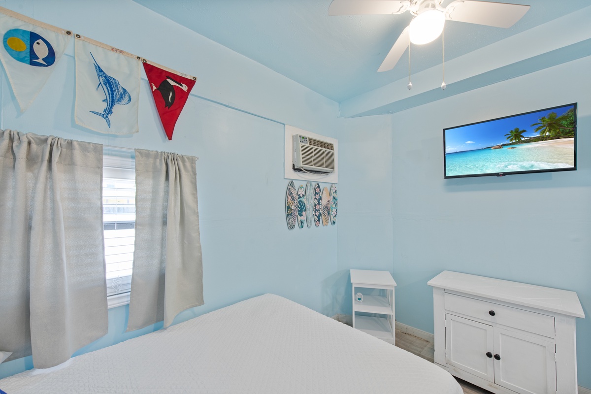 Wake up in your coastal-themed bedroom with cheerful blue walls, nautical décor, and a mounted TV for relaxing evenings.