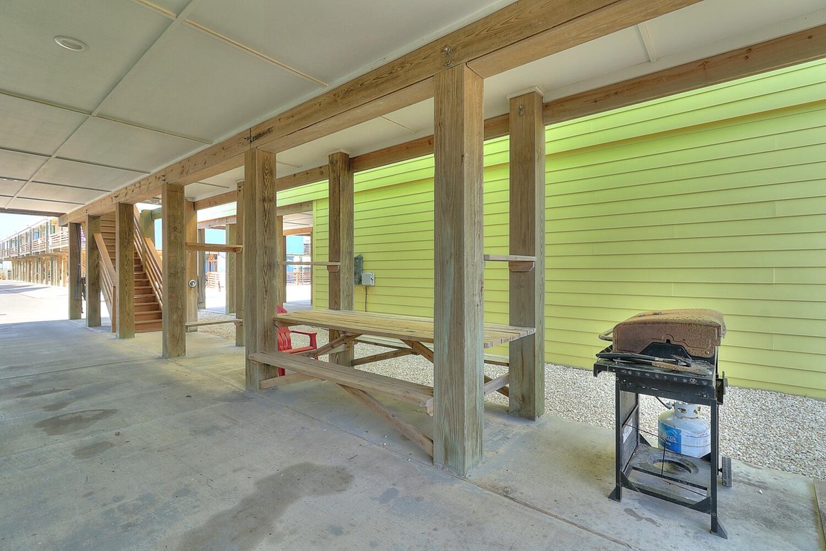 Your covered ground-floor area features a picnic table and gas grill, perfect for outdoor dining while staying protected from the elements.