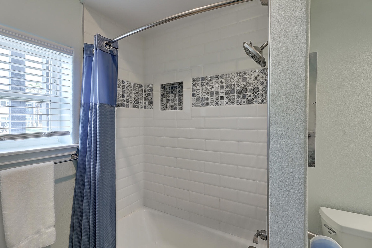 Step into your stylish bathroom with beautiful mosaic tile accents and a spacious shower-tub combo for refreshing mornings.