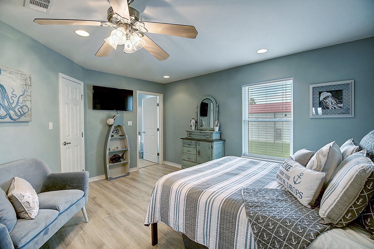 Drift off in this coastal bedroom where nautical charm meets modern comfort—your ceiling fan and soft linens ensure perfect sleep.