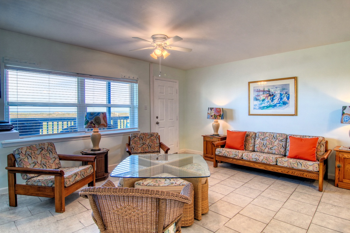 Relax in your bright living room with cozy seating, tropical artwork, and views through large windows.