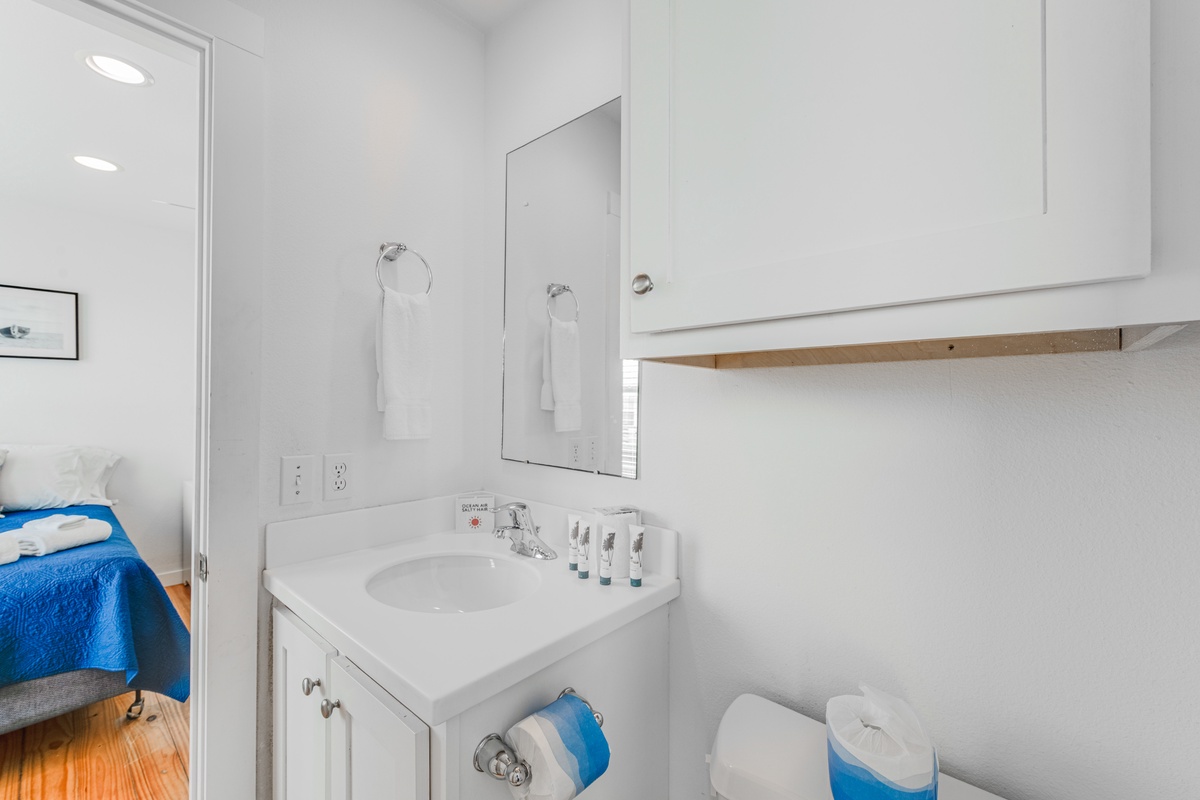 Step into your spotless private bathroom featuring fresh white fixtures, premium toiletries, and plush towels for your comfort.