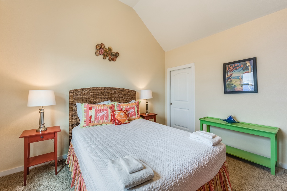 Drift off in your serene bedroom, featuring a wicker headboard, coral accents, and thoughtful touches that create the perfect coastal retreat.