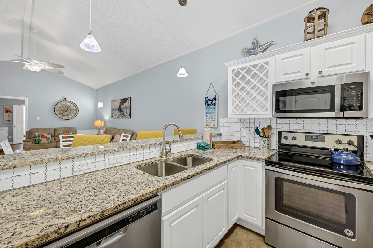 Your bright coastal kitchen invites cooking with granite counters, stainless appliances, and ocean-themed touches that make meal prep feel like a beachside retreat.