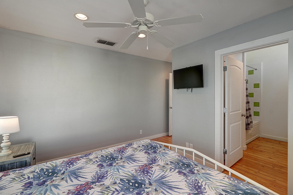 Rest peacefully in your cozy bedroom with soft gray walls, hardwood floors, and tropical-inspired bedding that'll make you feel instantly at home.